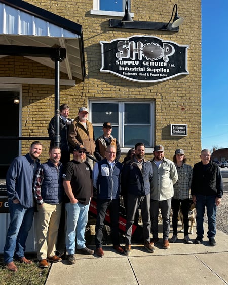 The Shop Supply Service team poses outside of their store.